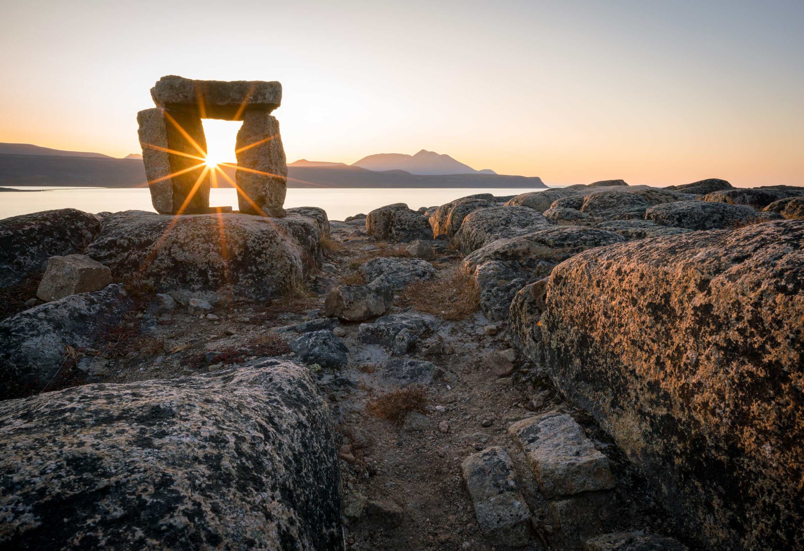 sun shining through inukshuk